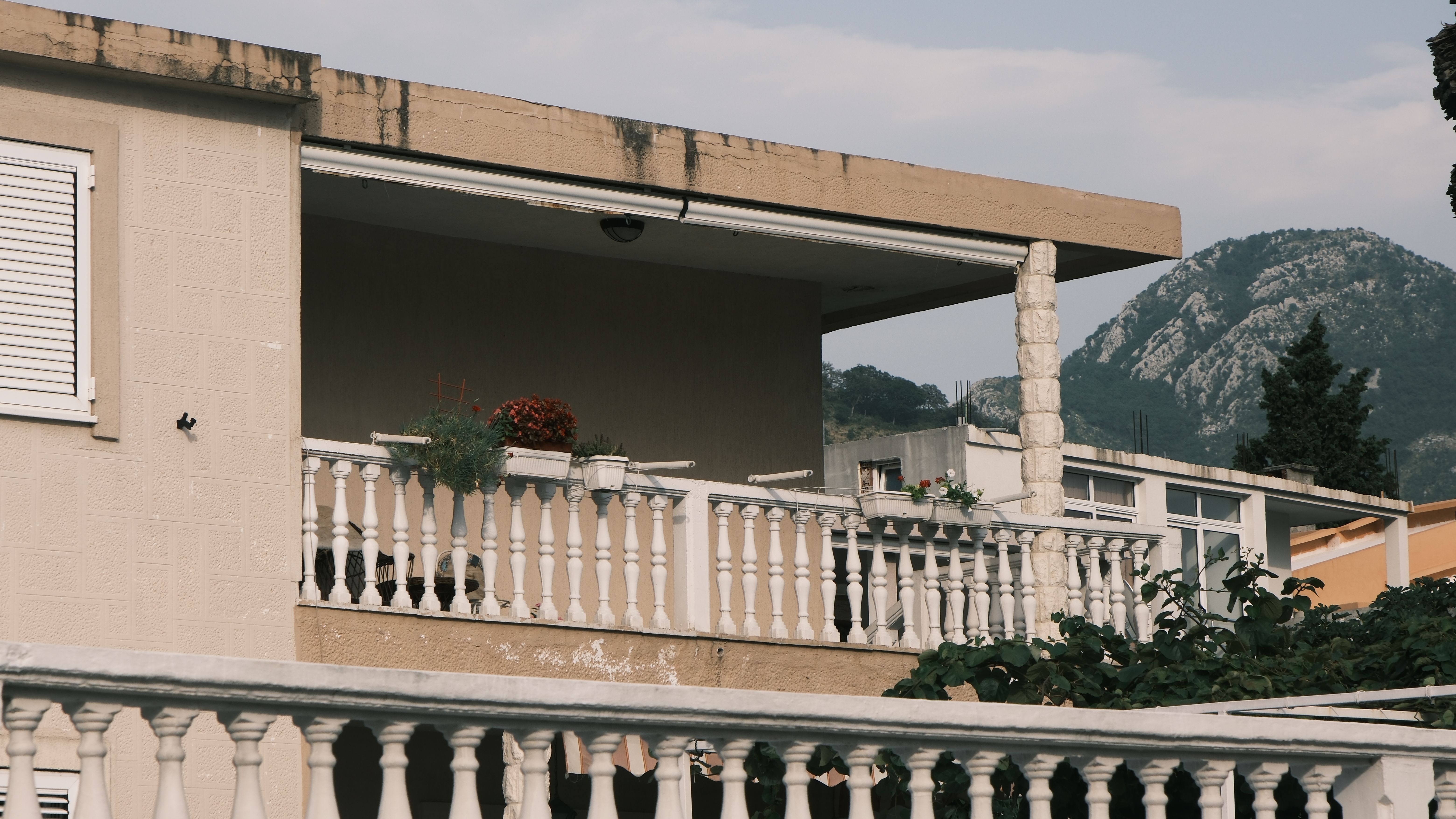 Majhen balkon z lončnicami in urbani pogled