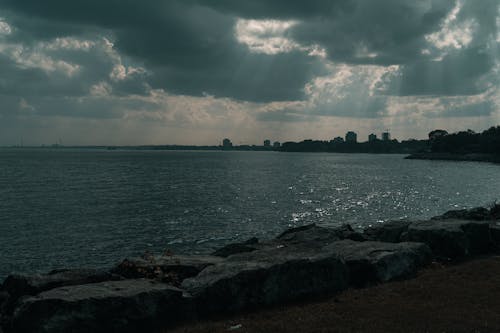 A man is standing on the shoreline looking out at the ocean