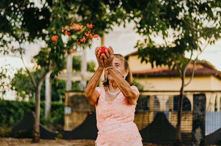 Woman In Pink Dress Throwing Flowers