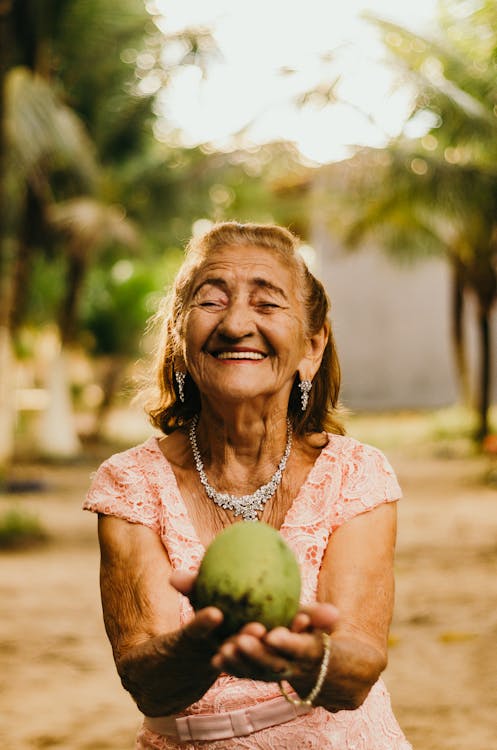 Woman Wearing Pink Dress Holding Fruit