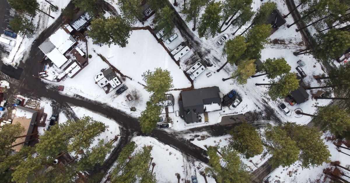 Drone's eye view of snow-covered trees and houses in Zephyr Cove, Nevada.