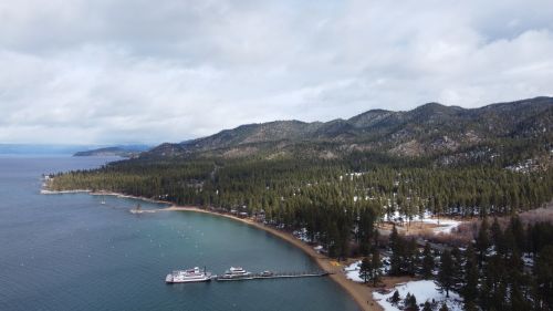 Free A breathtaking winter aerial view of Lake Tahoe's Glenbrook shoreline with snowy hills and lush forests. Stock Photo