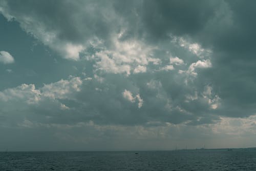 A boat is sailing under a cloudy sky