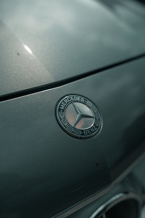 A close up of the mercedes logo on the hood of a car