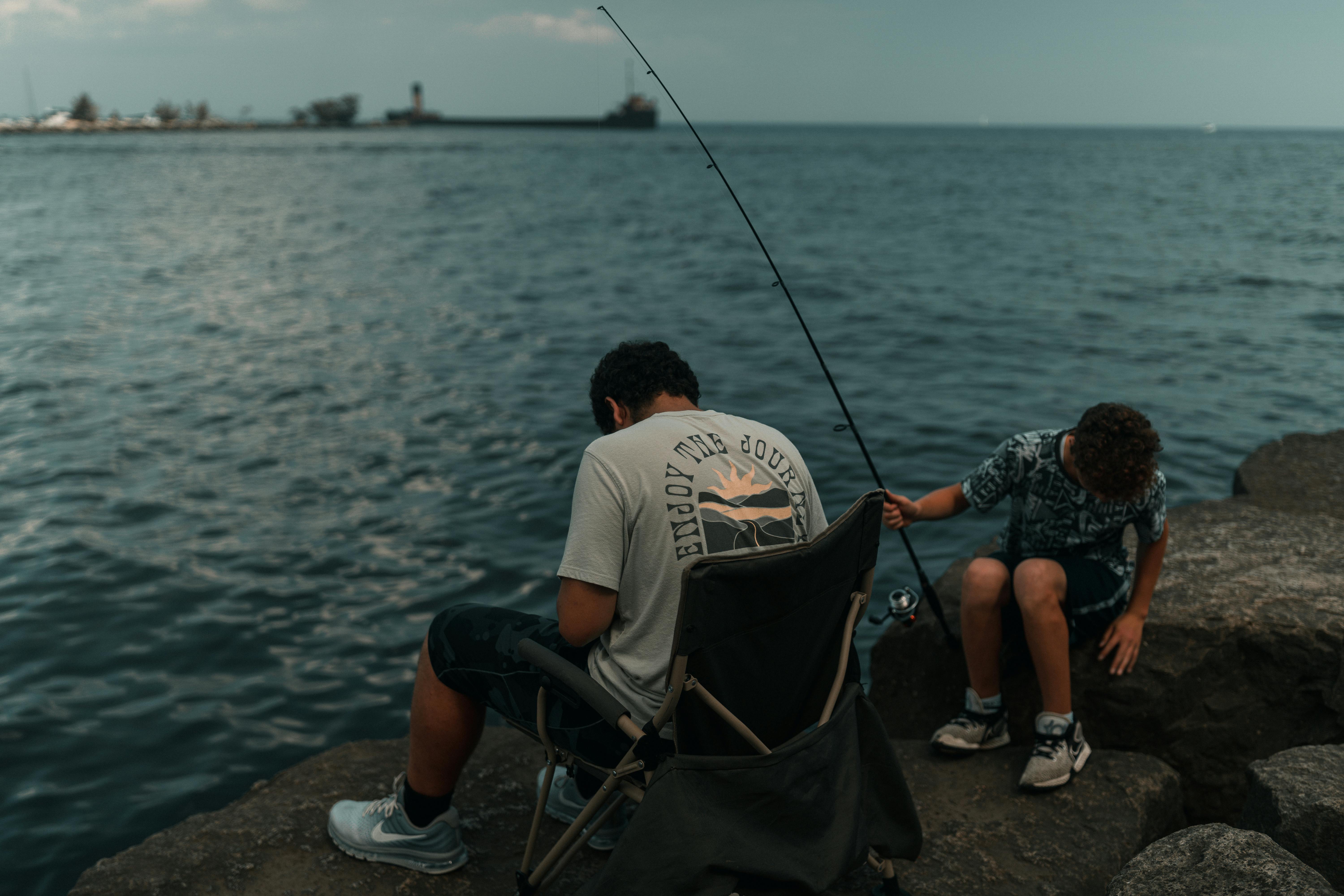 a man and a boy fishing on the rocks