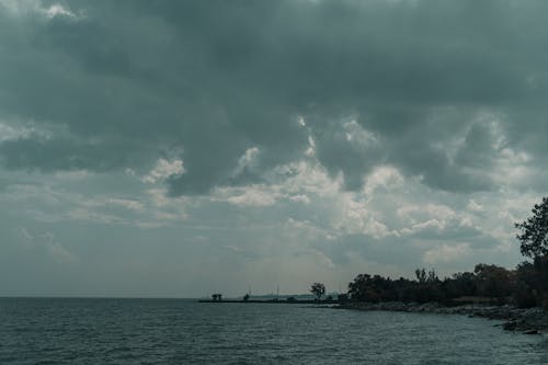 A cloudy sky over the water with a boat