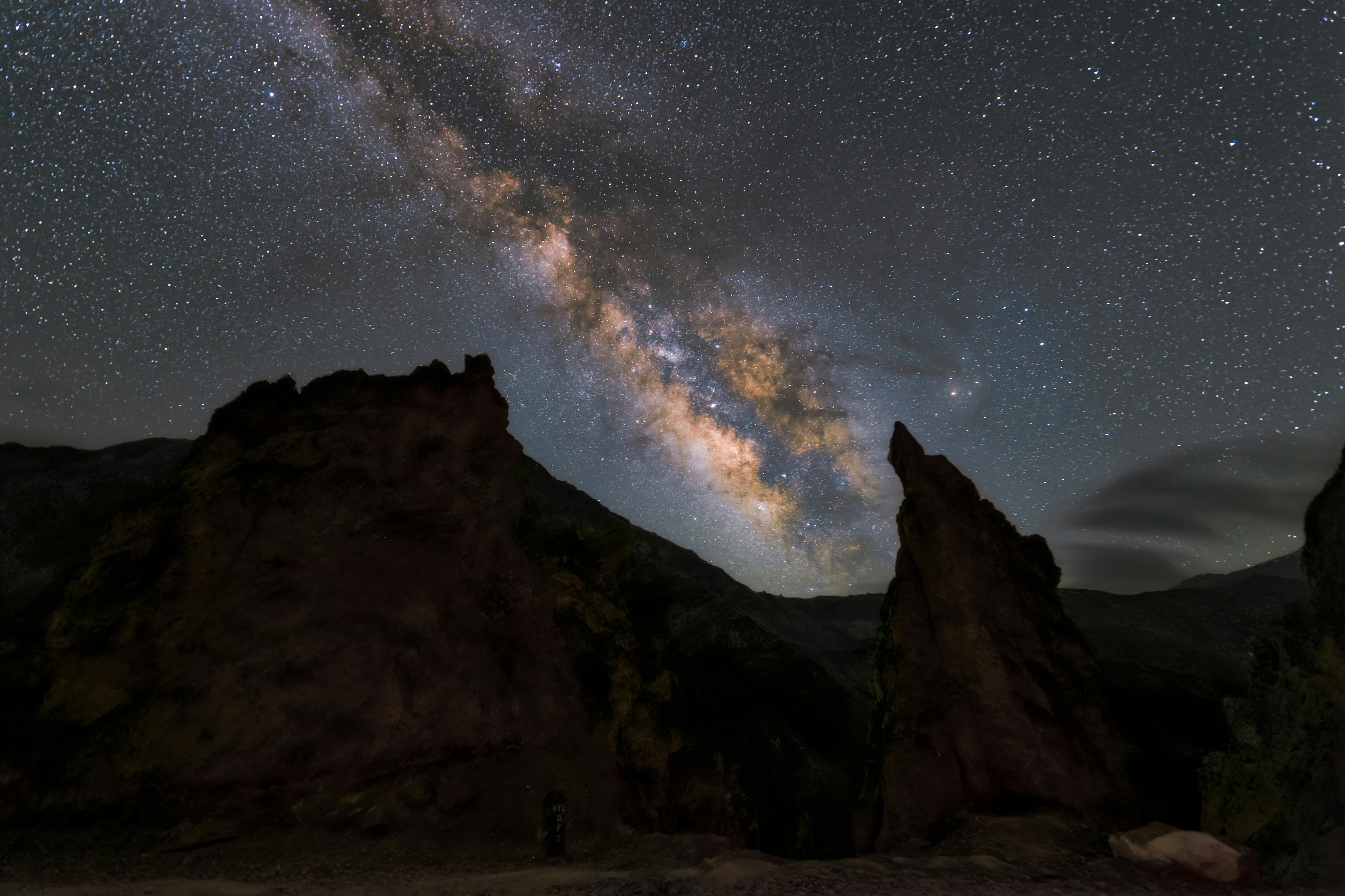 the milky shines over the rocks in the night sky