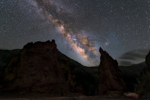 The milky shines over the rocks in the night sky