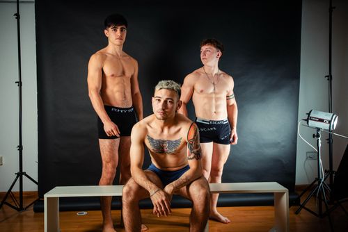Free A striking studio photoshoot featuring topless male models with tattoos and various poses. Stock Photo