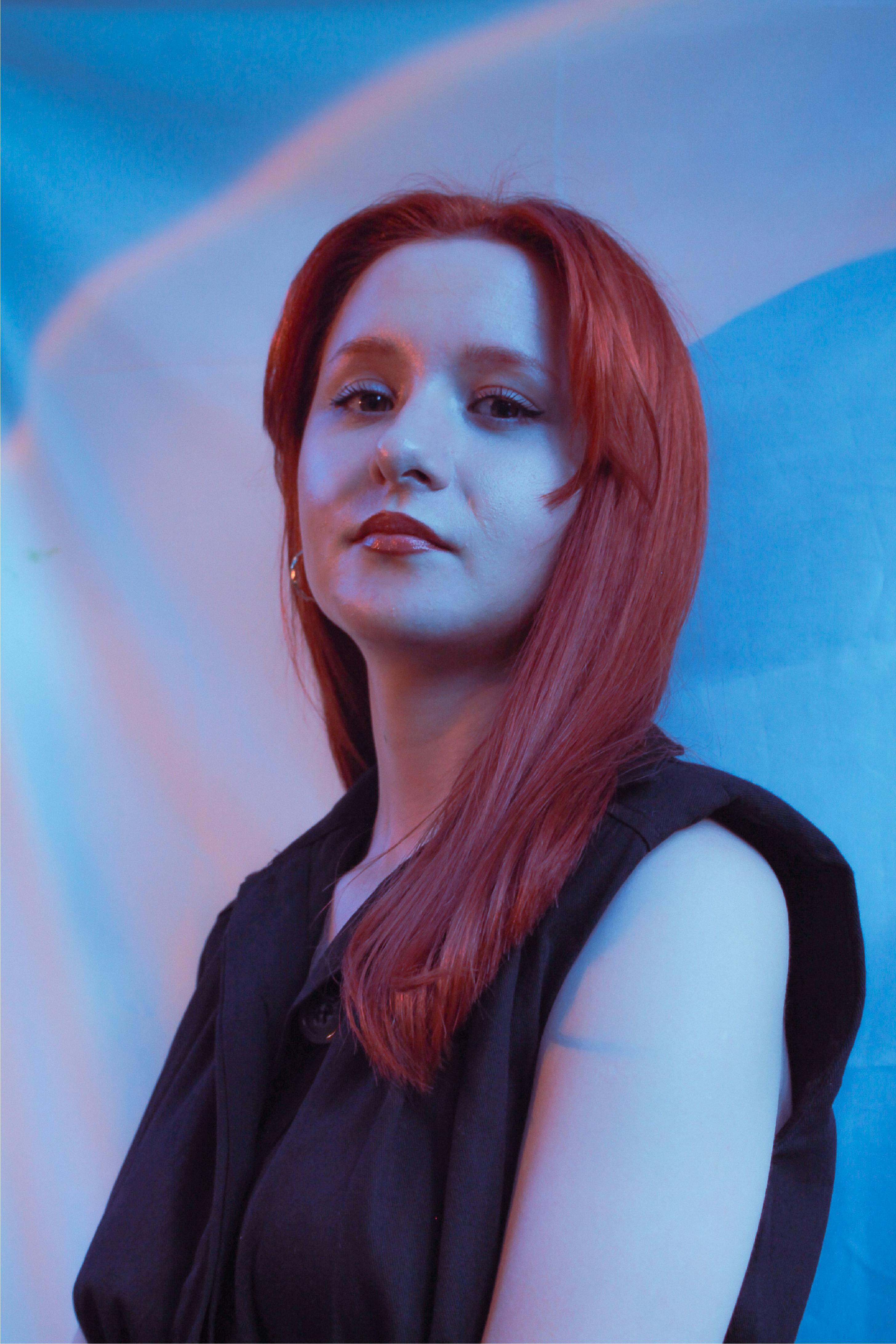 Kostenlos Künstlerisches Porträt einer Frau mit roten Haaren vor blauem Hintergrund. Stock-Foto