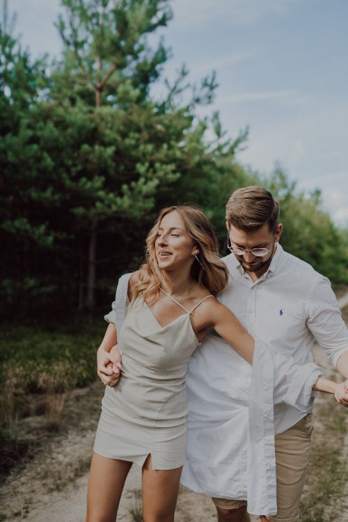 Free Happy couple walking through the park, enjoying a sunny day together. Stock Photo