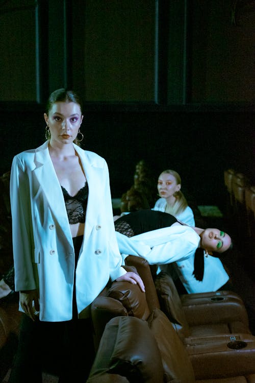 Glamour Models in White Jackets Posing in Luxury Cinema