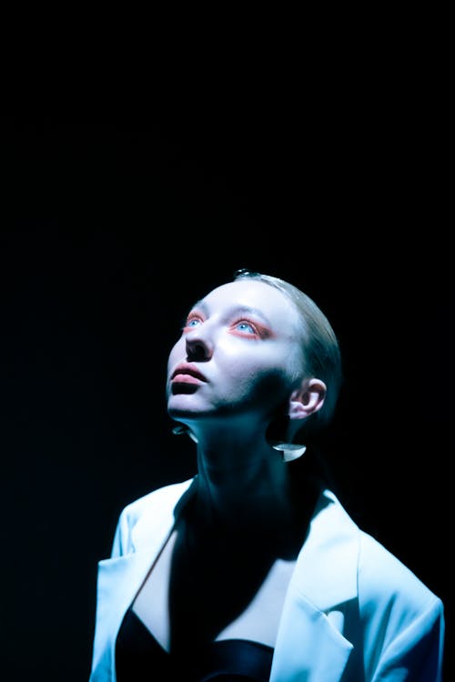 Young Woman in White Jacket Looking Up