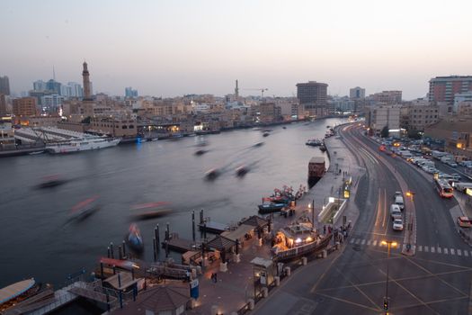 A serene aerial view of bustling Dubai Creek at dusk, highlighting the city's modern and historic blend.