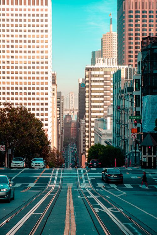 Free Iconic view of San Francisco's downtown with cable car tracks and skyscrapers, showcasing urban life. Stock Photo