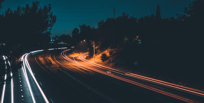 Captivating long exposure photo of a highway at night showcasing vibrant light trails from moving cars.
