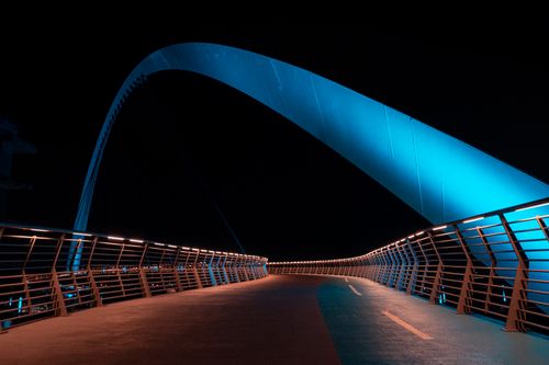 Free A stunning view of a modern illuminated bridge in Dubai nightscape. Stock Photo