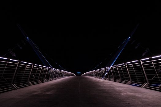 Beleuchtete Fußgängerbrücke bei Nacht