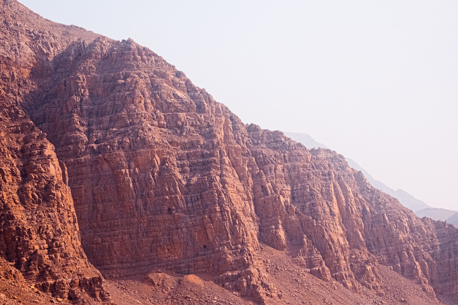 Stunning view of red rocky cliffs at Wadi Rum, capturing the arid desert landscape.