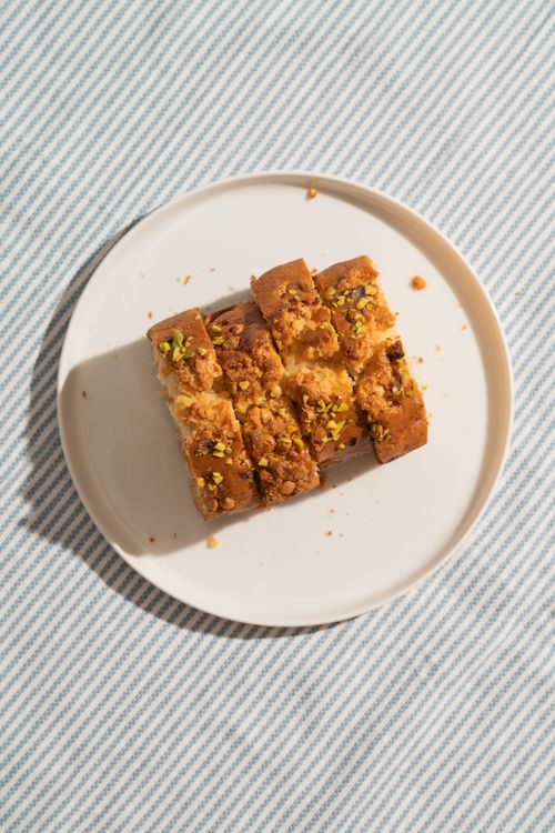 Free Top view of nut-topped cake slices on a plate with striped background, perfect for dessert themes. Stock Photo