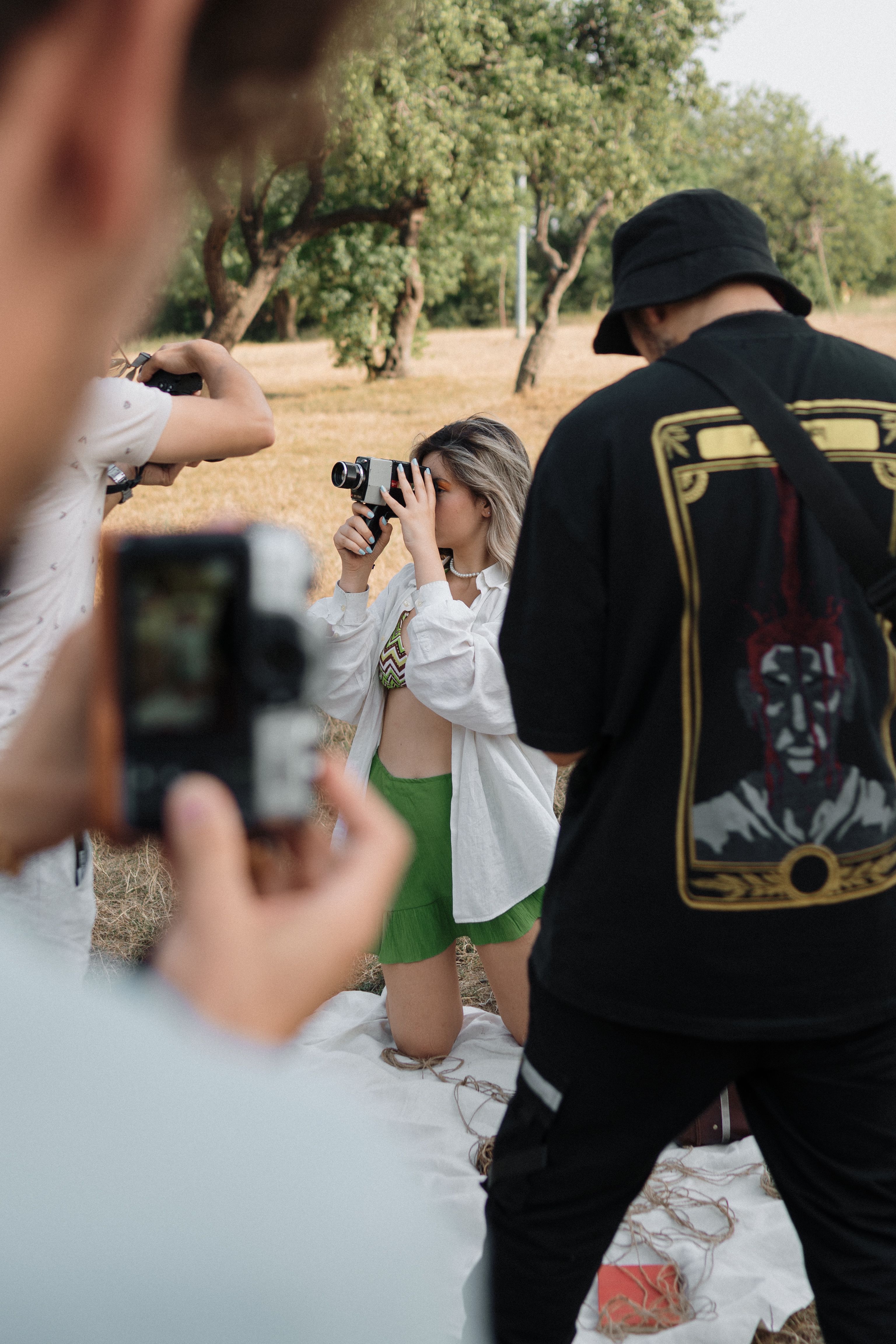 Group of photographers engaging in an outdoor photo session on a sunny summer day.
