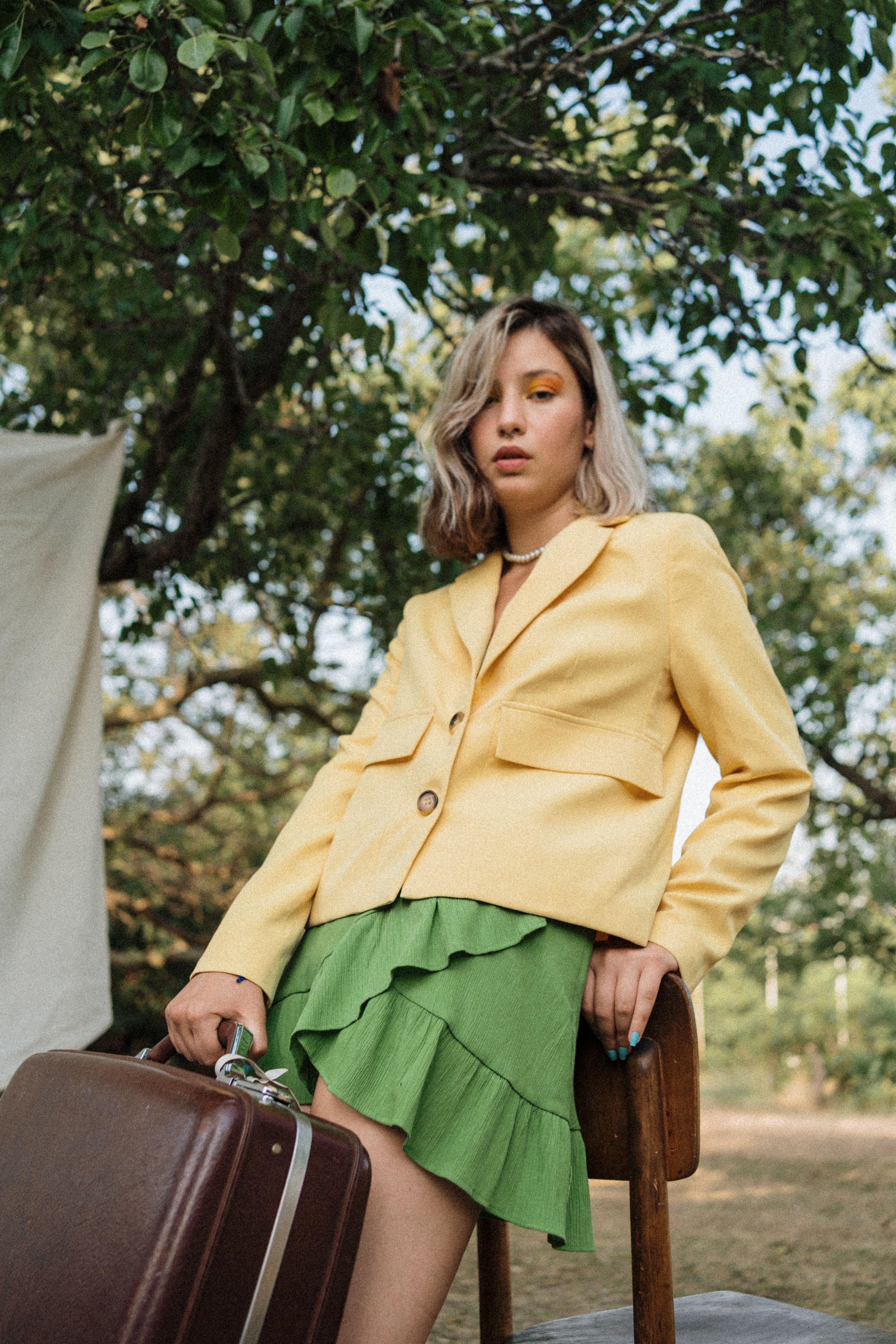Woman in Yellow Jacket and Green Skirt Leaning on Chair · Free Stock Photo