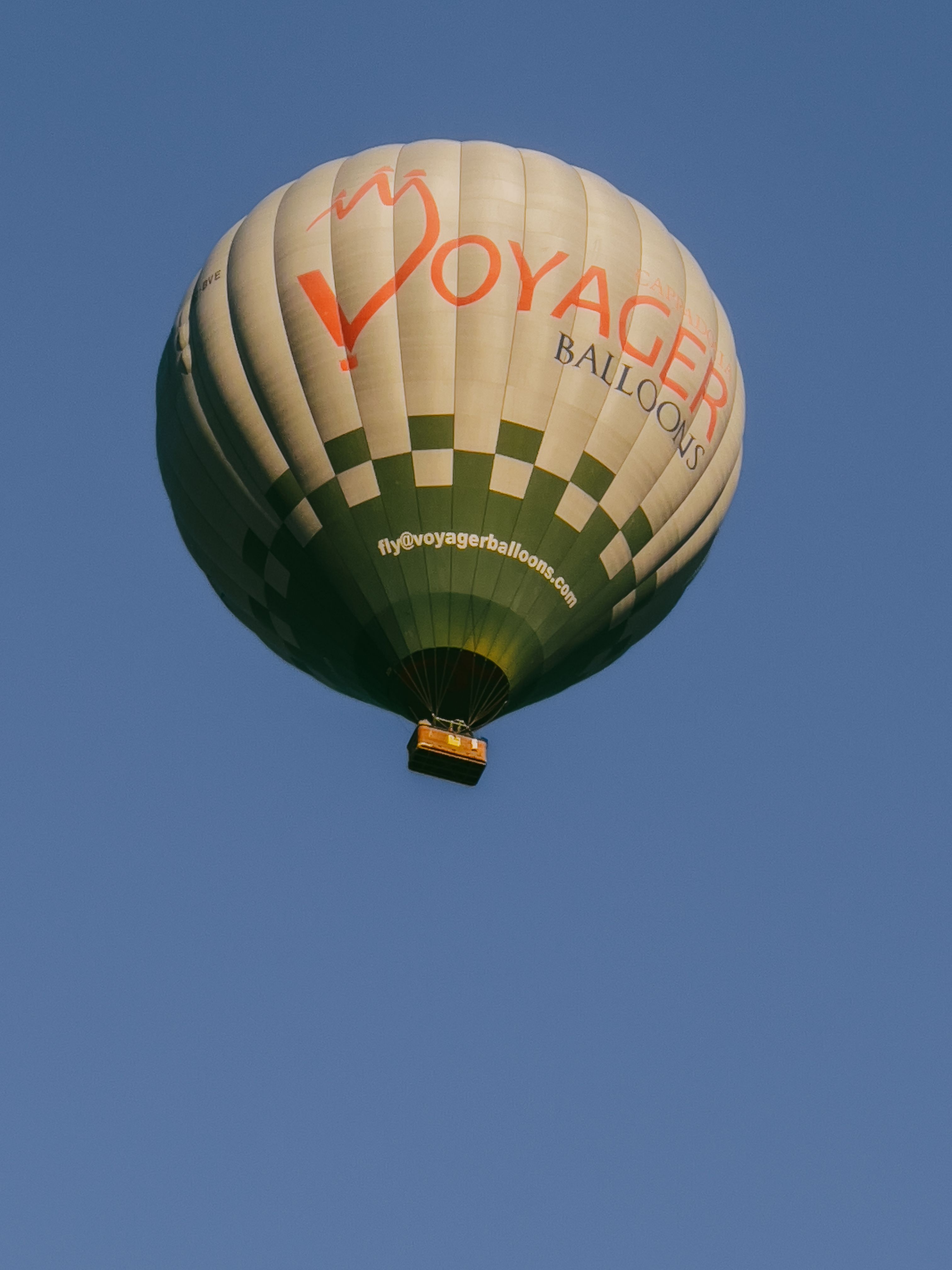 Spectacular hot air balloon flying over Göreme, Türkiye during a clear summer day.