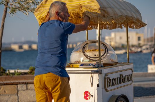 Street vendor selling Buzlu Badem nuts at a seaside point in Foça, Türkiye.