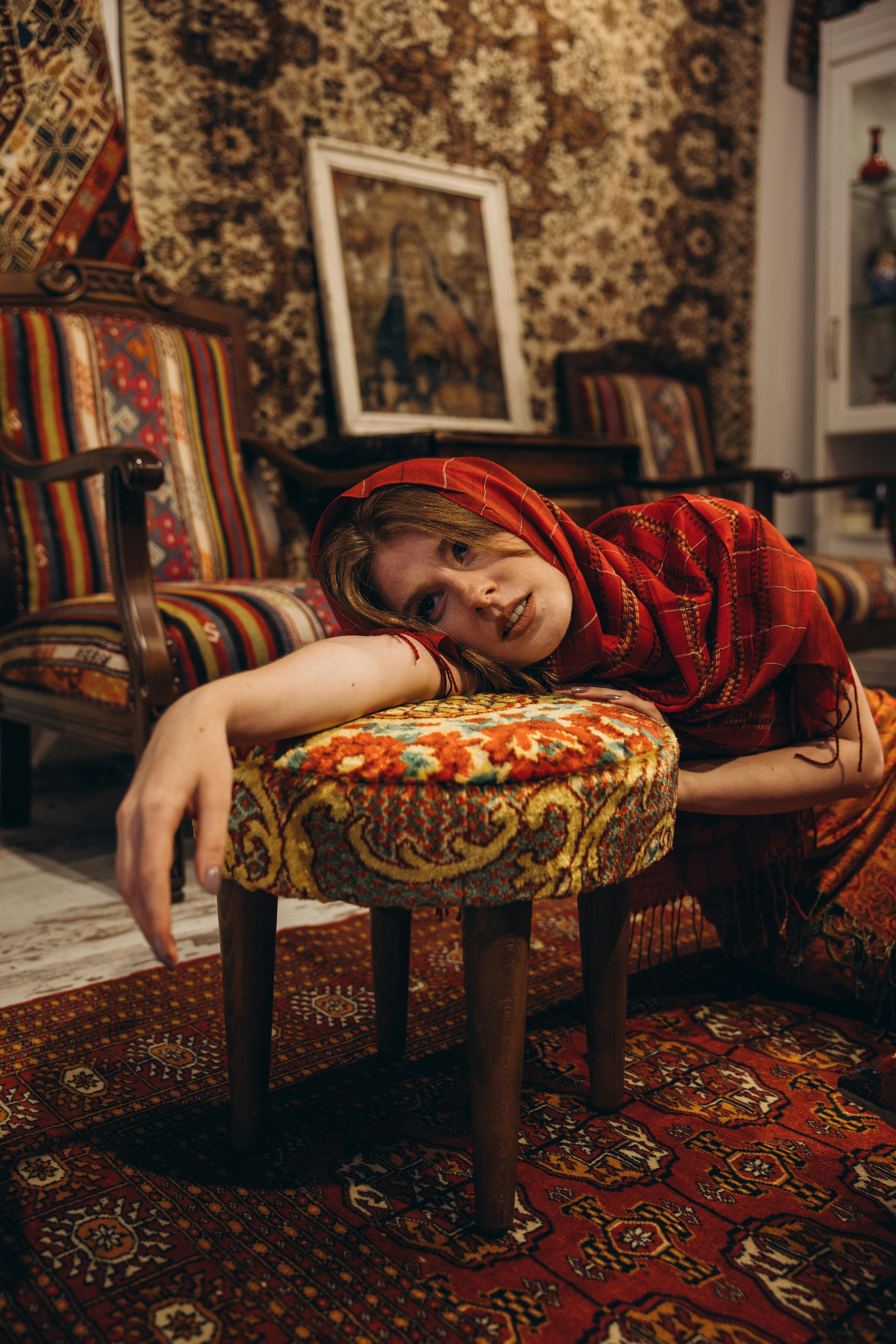 a woman in a red scarf laying on a chair