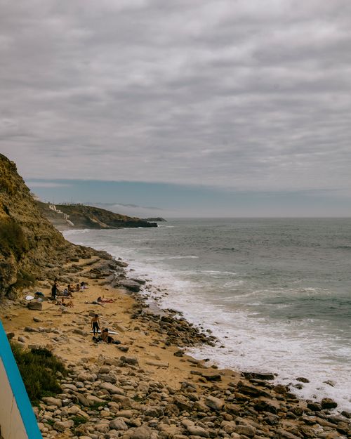 Free A serene rocky beach scene under overcast skies, perfect for travel and relaxation. Stock Photo