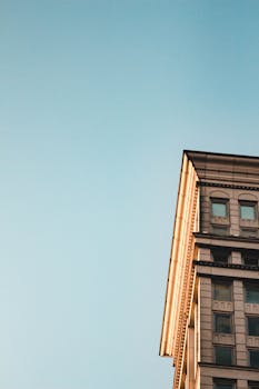 Low angle view of an elegant urban building against a clear blue sky.