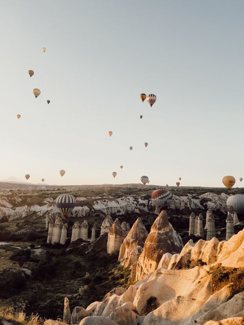Free Hot air balloons soaring over Cappadocia's stunning rock formations during a peaceful day. Stock Photo