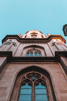 哥特式教堂塔楼的低角度视图引人注目，与清澈的蓝天形成了鲜明对比