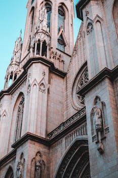 从低角度仰望哥特式大教堂的立面，可见其复杂的石雕与高耸的结构