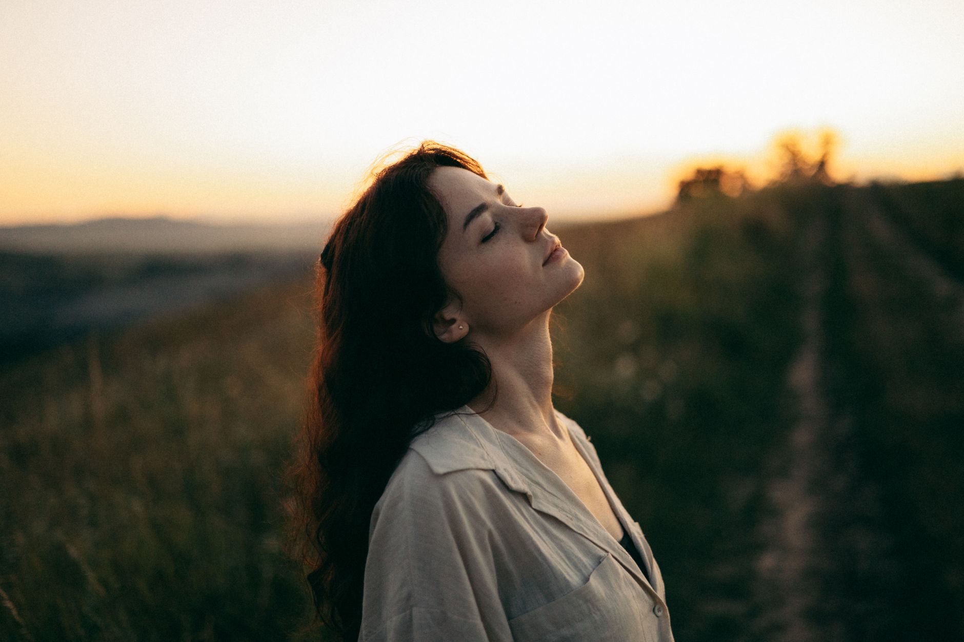 https://www.pexels.com/photo/beautiful-young-woman-standing-in-the-meadow-with-eyes-closed-17867916/