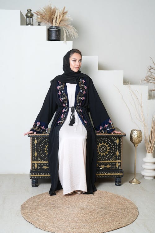 Model in Black Clothes and Hijab on Dresser in Room