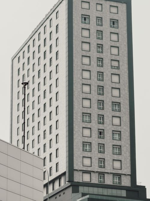 Free Close-up of a modern high-rise building facade with grid windows, emphasizing urban architecture. Stock Photo