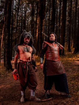 Two costumed warriors stand in a Mexican forest, embodying strength and tradition.