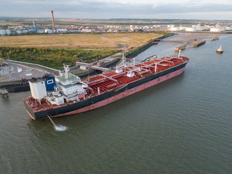 Aerial view of a large cargo ship docked in an industrial harbor, showcasing the vessel's capacity.
