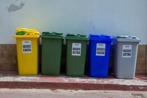 Free Five colorful recycling bins organized for waste segregation in an urban setting. Stock Photo