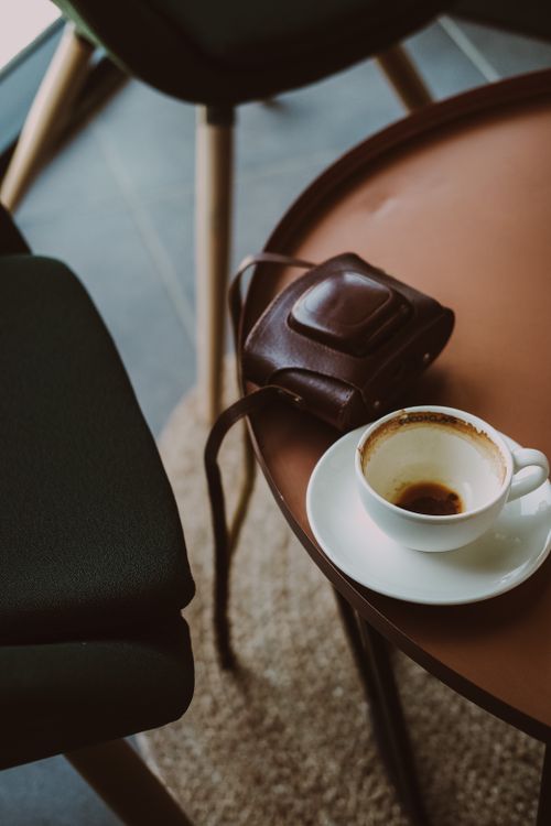Free A warm, inviting scene with a cup of coffee and a camera case on a table in Ankara, Türkiye. Stock Photo