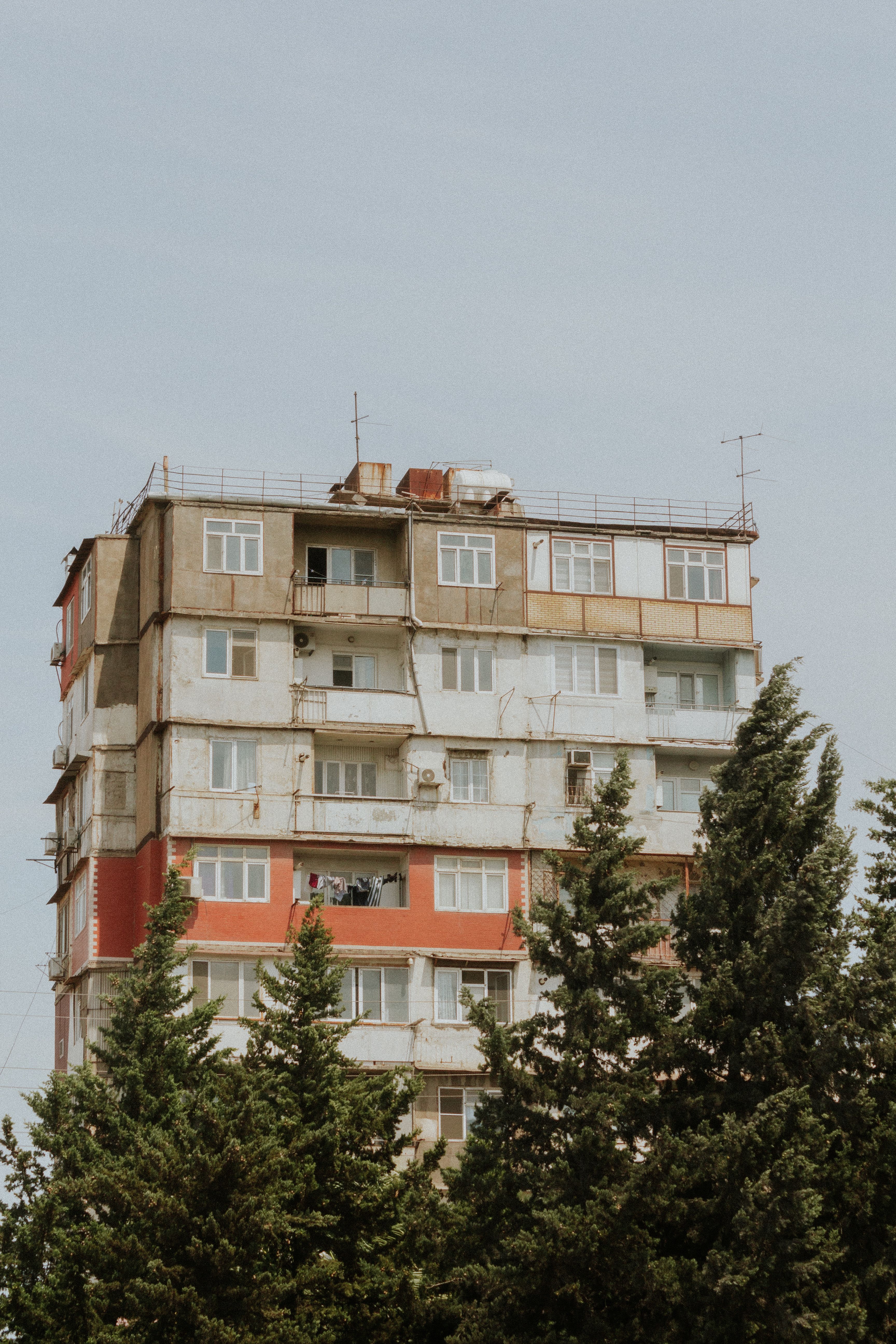 Building with Apartments behind Trees · Free Stock Photo