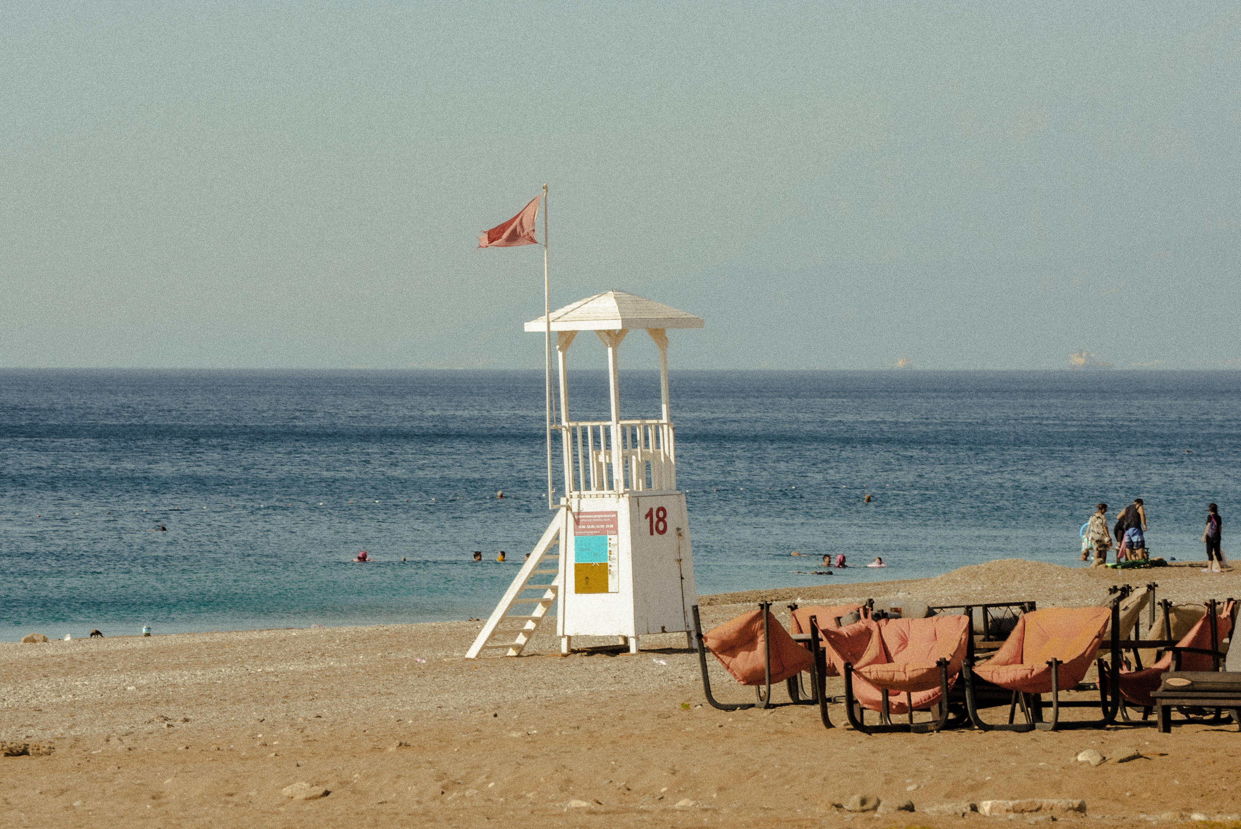 Lifeguard tower and flag on a Cyprus beach with clear turquoise water