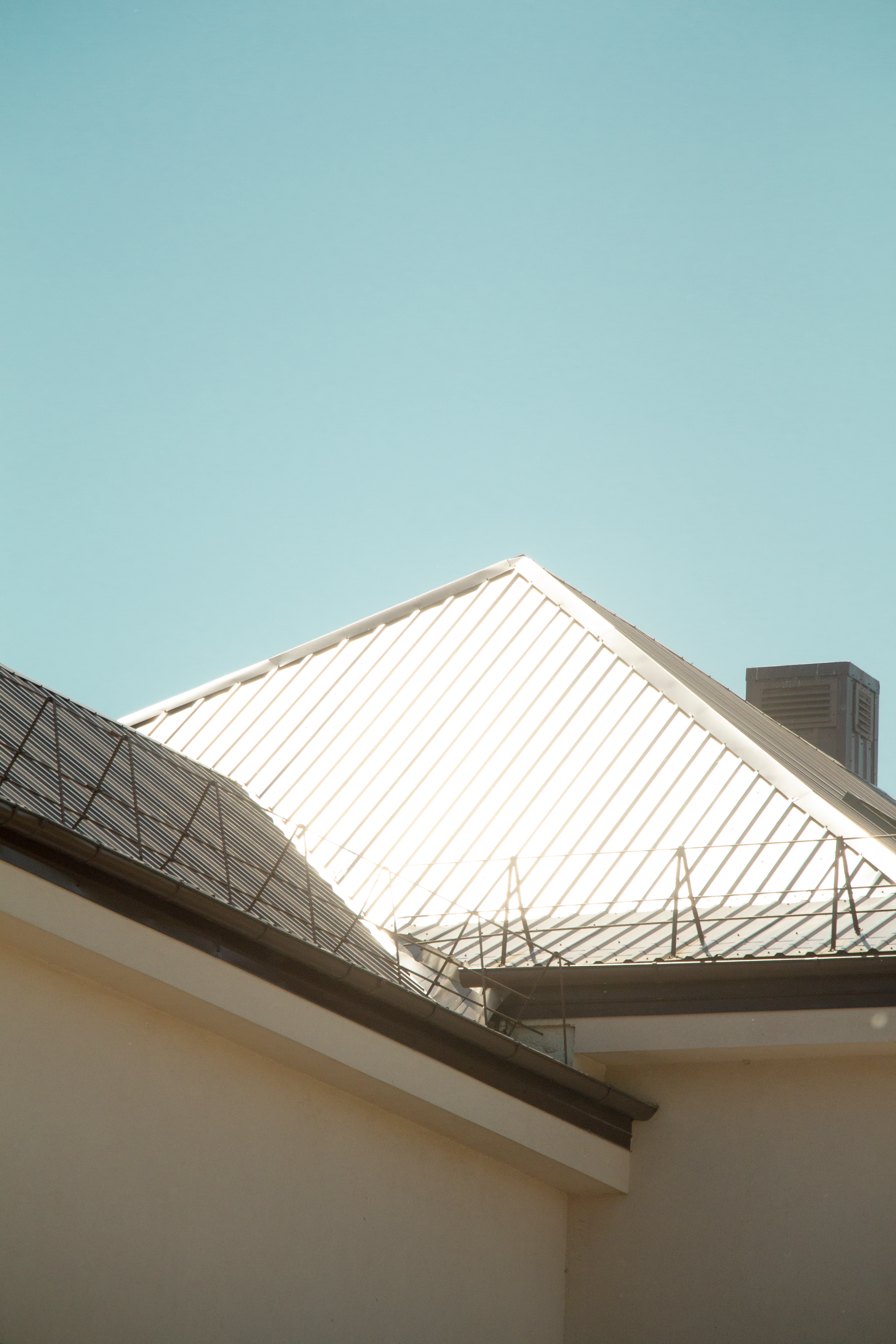 Minimalistic view of a metal roof shining under sunlight, perfect for modern architecture themes.