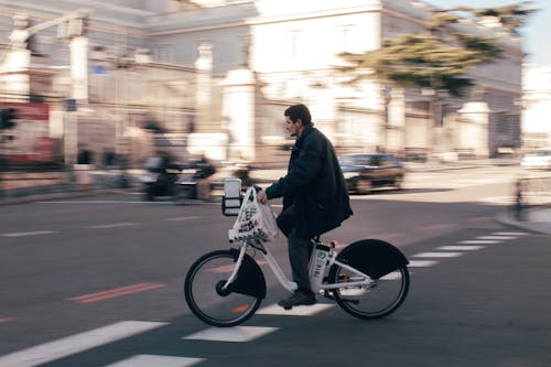 Man on Electric Bike on Street in City