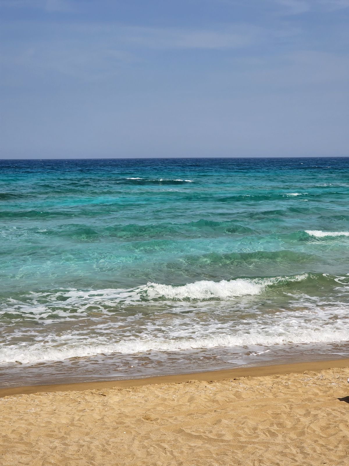 Turquoise waves on the long sandy coast at Iskele