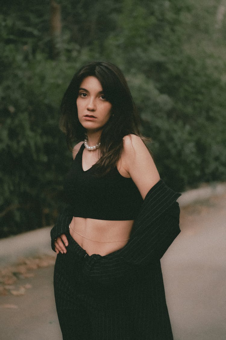 Woman In Black Crop Top And Pearls Holding Hands On Hips