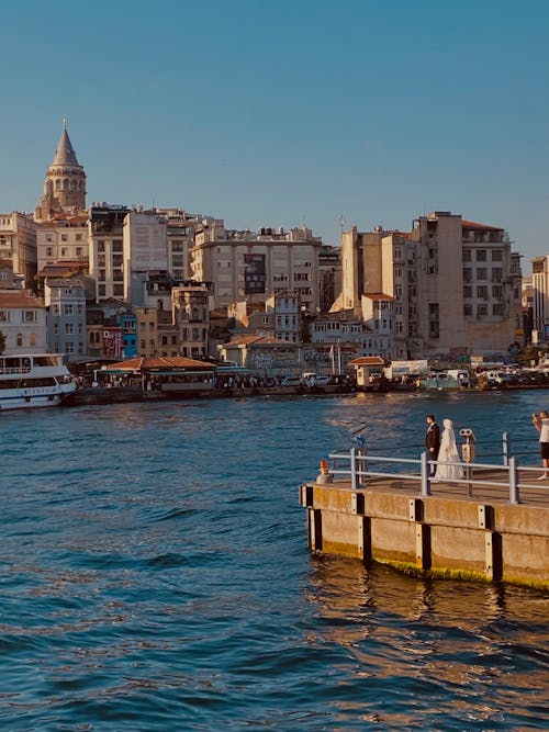 Newlyweds on Pier on Shore near Galata Tower in Istanbul 