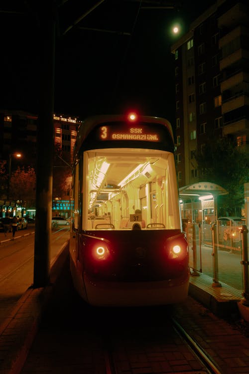 Illuminated Tram on Stop at Night