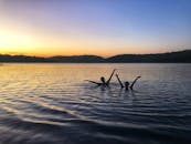 日落时分，两个人在宁静的湖中游泳，捕捉到大自然的宁静时刻